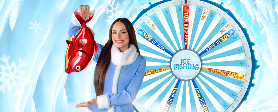 Smiling live casino host holding a red cartoon fish in front of the Ice Fishing game wheel – exclusive Arctic-themed experience. - -