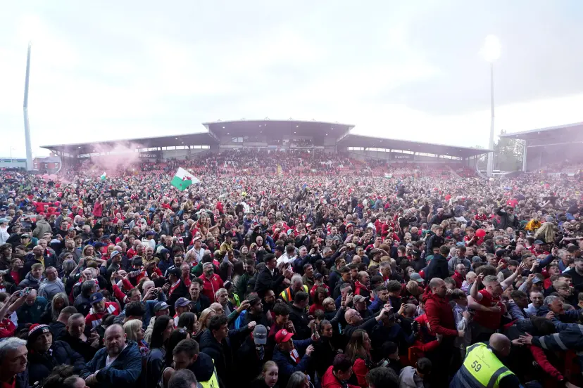 Wrexham's fans on the pitch after Wrexham won promotion to the Sky Bet Championship after the Sky Bet League One match at SToK Racecourse, Wrexham. Picture date: Saturday April 26, 2025